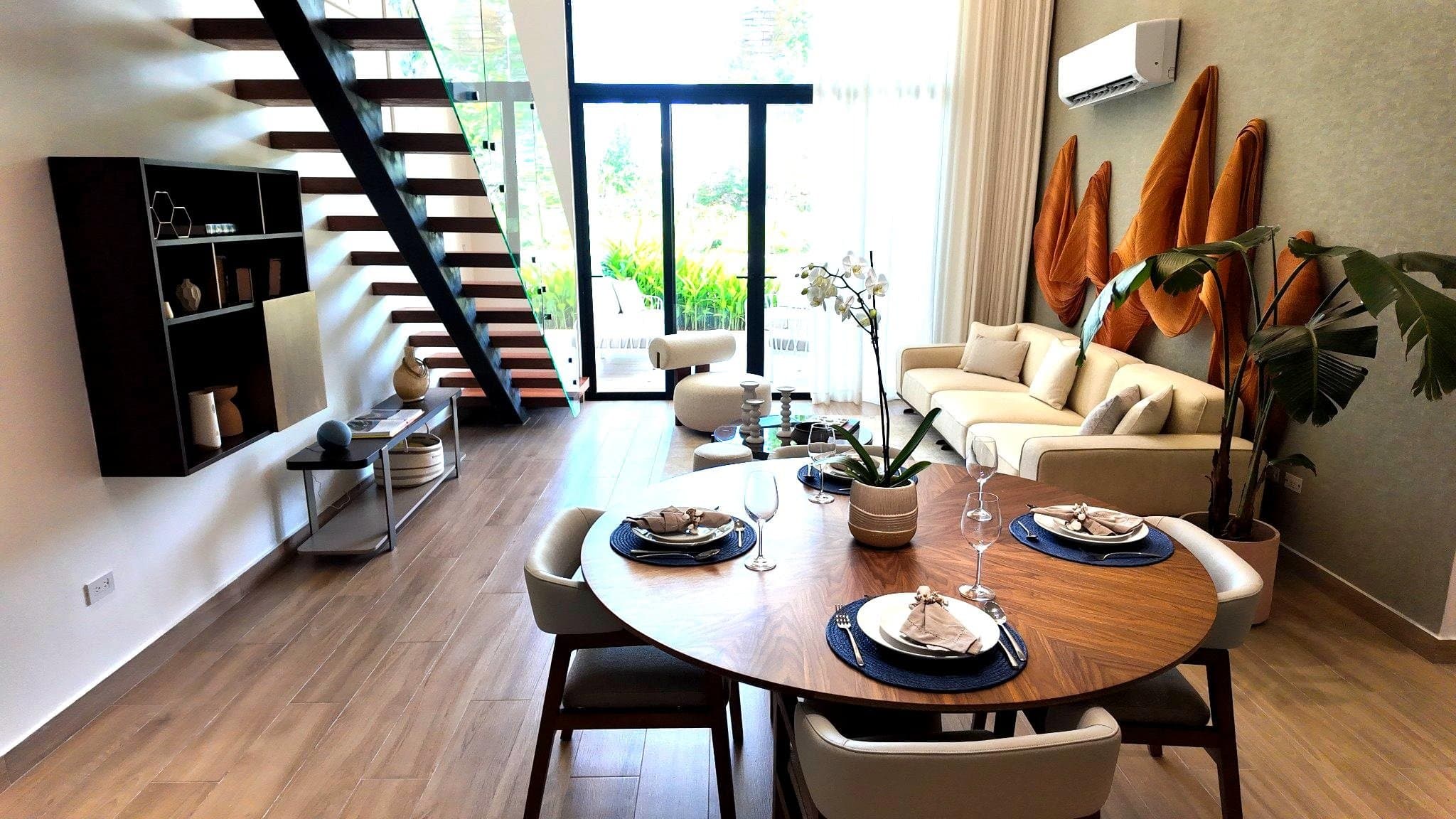Dining table beneath an open-tread timber staircase
