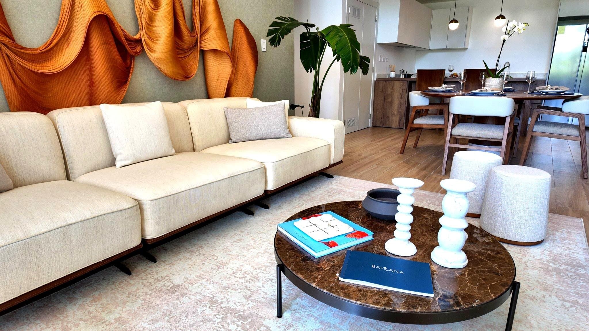 Living area with long sofa, marble table and sculptural wall art